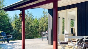 A wooden deck with outdoor furniture, a covered area, and a view of trees and a building. - 6 Person Holiday Home in Albaek-by Traum (Aalbaek)