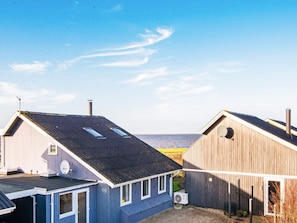 A coastal building with a sloped roof, a satellite dish, and a chimney.