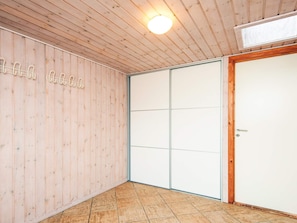 A room with wooden walls, a sliding door, and a ceiling light fixture.