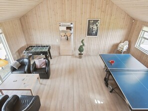 Et rum med et fodboldbord, et pingpongbord og et lille bord med spillekort.