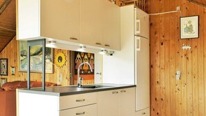 A compact kitchen with white cabinets, a sink, and a wooden wall. - 6 Person Holiday Home in Vejers Strand-by Traum (Vejers Strand)