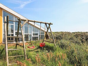 A modern building with large windows and a wooden structure in front. - 4 Star Holiday Home in Hjorring (Hjørring)