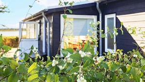 Uma casa móvel com vista para um lago, rodeada por vegetação.