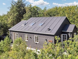 Et toetagers hus med mørkt tag, mange vinduer og et skilt med teksten 'Meyersbock'.