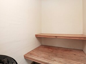 Un coin de pièce avec un banc en bois et un mur.
