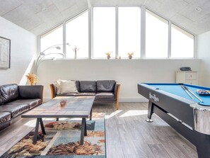 A room with a pool table, a leather sofa, a coffee table, and a large window. - 4 Star Holiday Home in Harboore (Harboore)