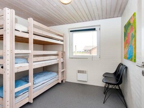 A bunk bed room with a window, a radiator, and a chair. - 4 Star Holiday Home in Harboore (Harboore)