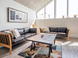 Un salón moderno con un sofá modular, una mesa de centro y un amplio ventanal que proporciona luz natural.