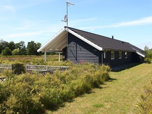 A single-story building with a sloped roof, a satellite dish, and a number '56' on the side.