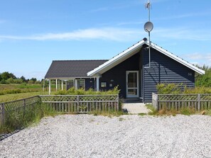 A dark-colored building with a sloped roof, a satellite dish, and a number '56' on the side.