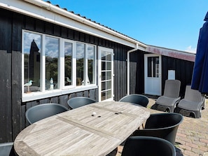 A wooden table with chairs, a window with a view, and a door.