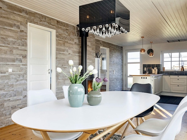 A modern kitchen with white cabinets, a black range hood, and a window above the sink.