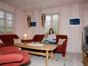 A living room with a red sofa, a wooden coffee table, and a television. - 8 Person Holiday Home in Rodby (Rodby)
