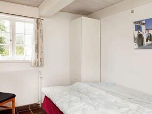 Cozy retreat with a single bed, window, and wardrobe.