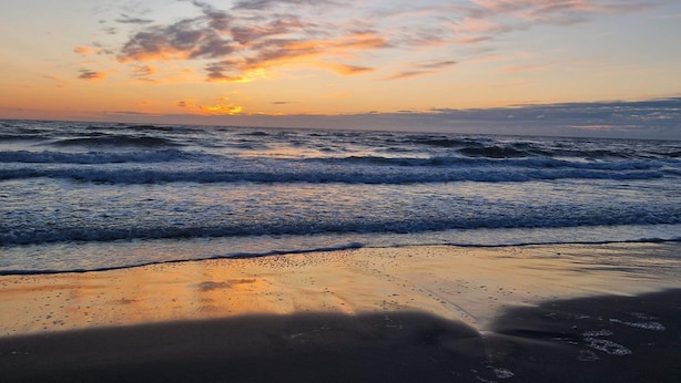 A beach with waves and a sunset. - 4 Star Holiday Home in Blokhus (Blokhus)