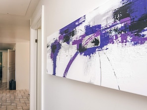 A hallway with a large abstract painting on the wall.