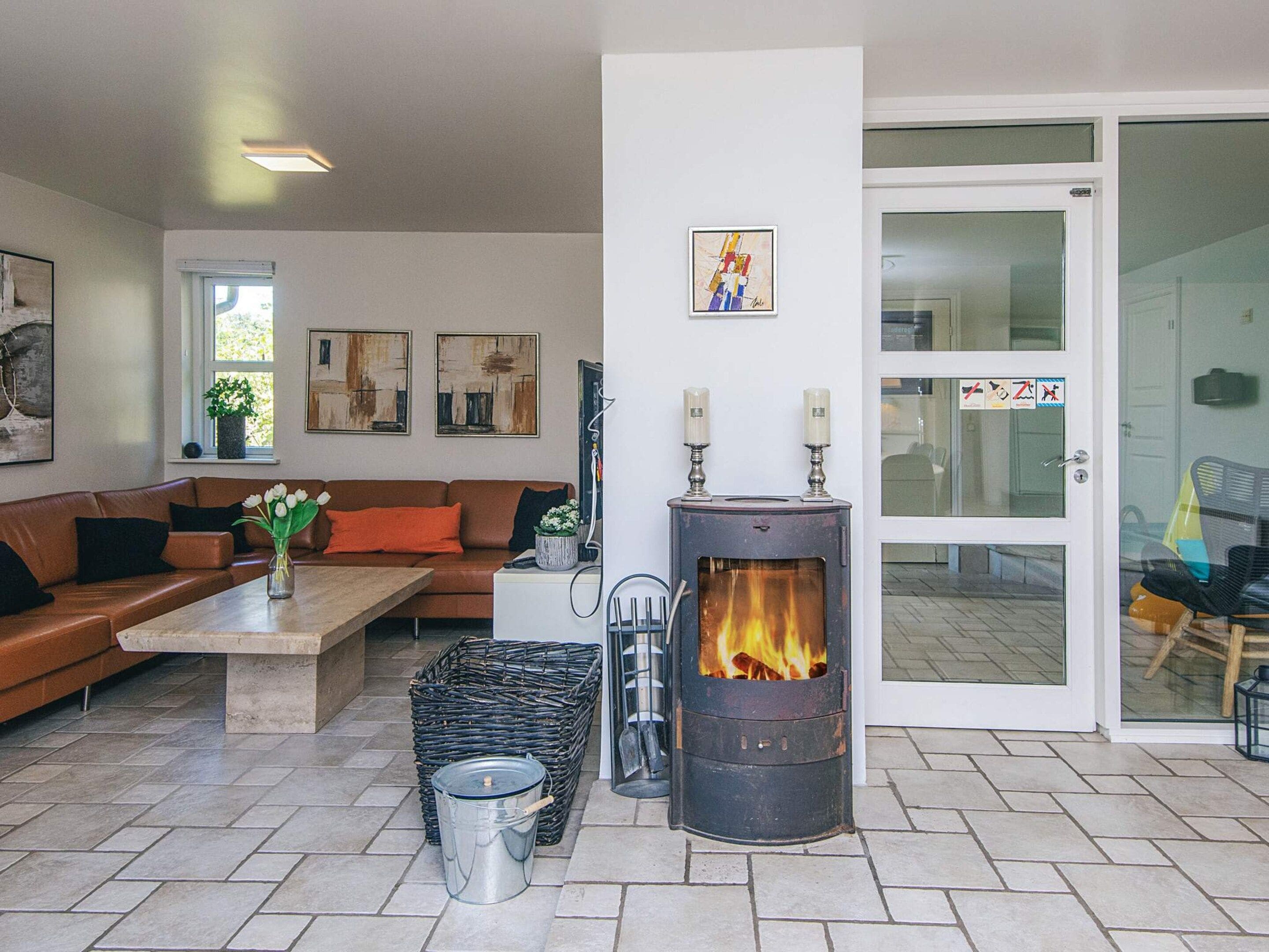 A living room with a fireplace, a sofa, a coffee table, and a door leading to another room.