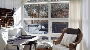 A sunlit room with a desk, chair, and large windows overlooking a garden. - Modern Holiday Home With Large Terrace in Fanø (Fano)