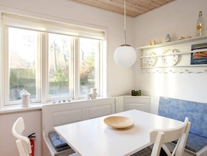 Enjoy meals at the dining table, surrounded by a view of trees through the window.