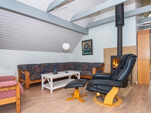 A cozy living room with a sofa, a black leather chair, a small table, and a fireplace.
