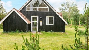 A two-story house with a black exterior, white trim, and a triangular roof. - 6 Person Holiday Home in Romo (Rømø)