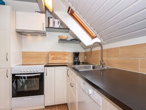 A compact kitchen with a built-in oven, a dishwasher, and a sink.