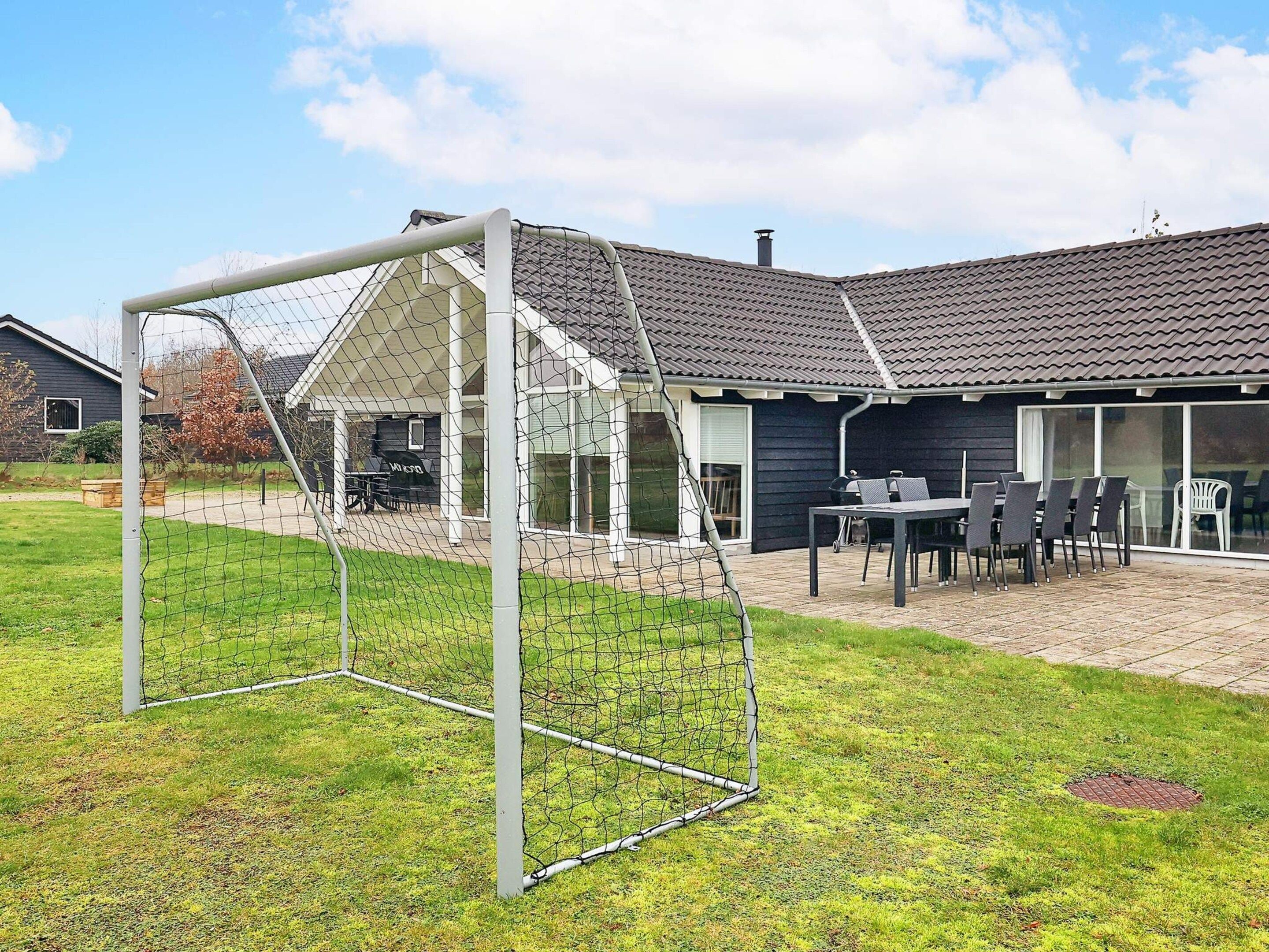 A residential property with a patio area, a covered outdoor seating area, and a fenced backyard.