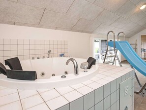 Une salle de bain avec une baignoire, une douche et un toboggan bleu.