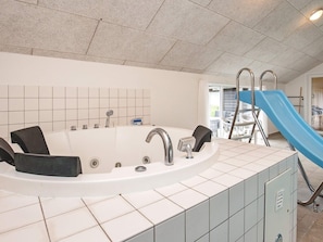 A bathroom with a bathtub, a shower, and a blue slide. - 5 Star Holiday Home in Hojslev (Hojslev)