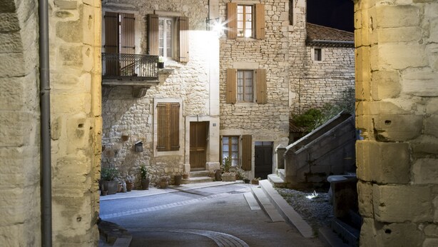 A narrow cobblestone street flanked by stone buildings with arched doorways and wooden shutters. - Gîte Léonie "Between Cèze and Ardèche" 30430 BARJAC (Barjac)