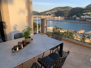 A balcony with a table, chairs, and a potted plant. - Private Detached Villa, sea and port view, several terraces, South facing (Port d'Andratx)