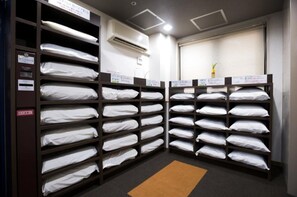 Storage room with neatly folded linens and a view of a plant outside.