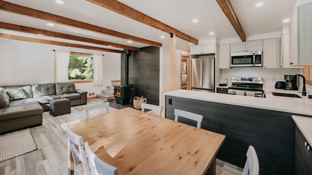 A modern kitchen with a central island, built-in appliances, and a cozy seating area with a fireplace.