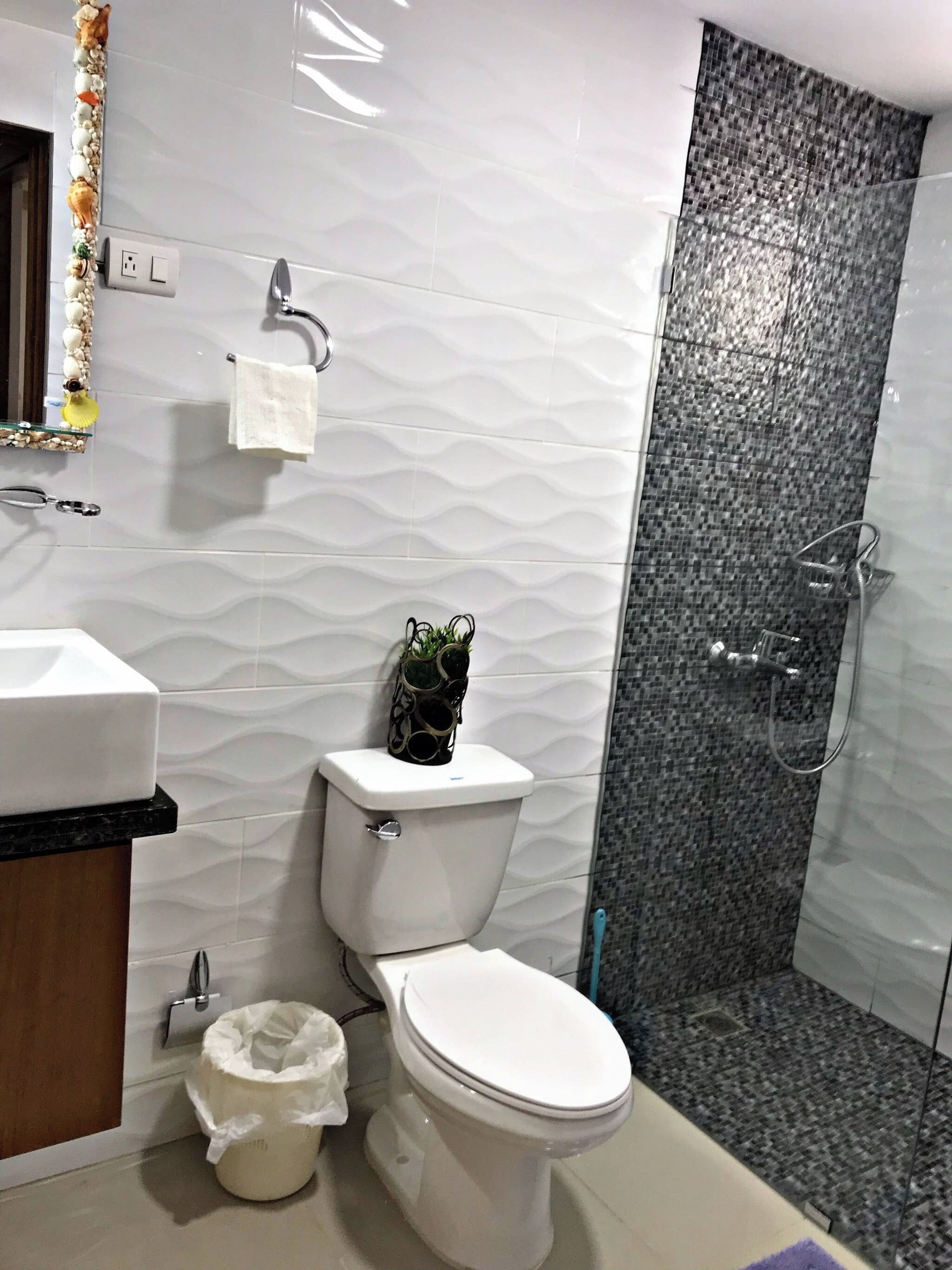 Ein Badezimmer mit Toilette, Waschbecken und Duschbereich.