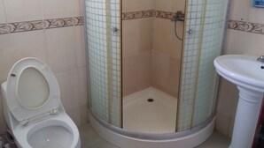 A bathroom with a toilet, a shower enclosure, and a sink. - Room-room With fan use Bavaro Punta Cana (Punta Cana)