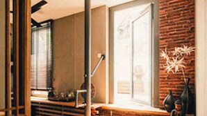 A modern interior with a wooden bench, a brick wall, and a window with blinds. - 36 Phô Cô Hotel & Suites (Weimar)