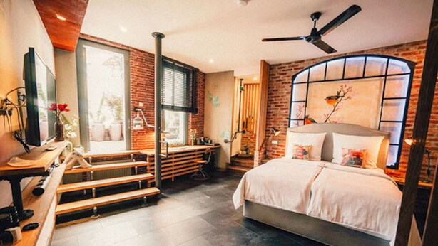 A modern bedroom with a large bed, a desk, and a window with a view of the outdoors. - 36 Phô Cô Hotel & Suites (Weimar)