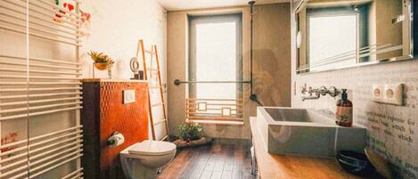 A compact bathroom with a toilet, sink, and shower area.