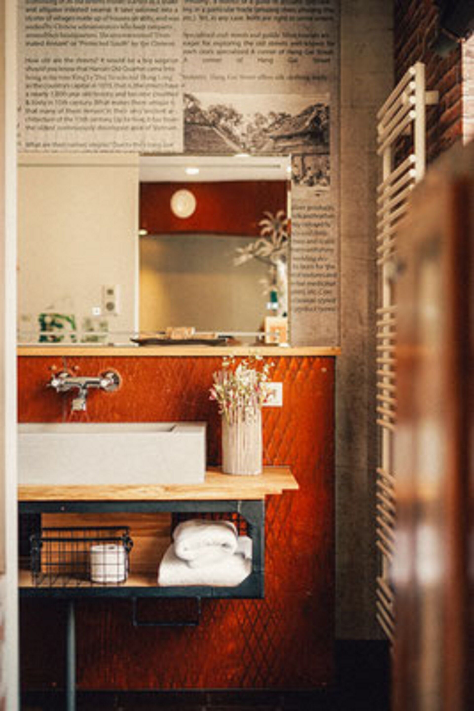 A bathroom with a wooden vanity, a mirror, and a towel rack.