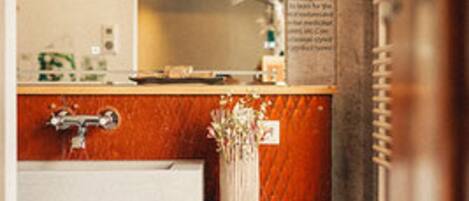 A bathroom with a wooden vanity, a mirror, and a towel rack.