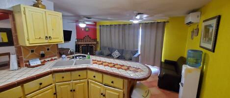 A kitchen with yellow cabinets, a tiled backsplash, and a built-in sink.