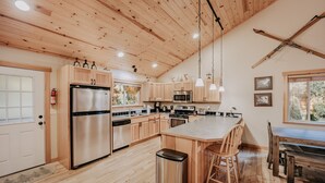 A modern kitchen with wooden cabinets, stainless steel appliances, and a central island with seating. - 65gs - Hot Tub - Wi-fi - Pets Ok - Bbq (Deming)
