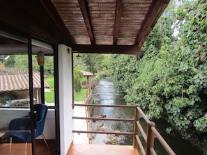Un espacio al aire libre techado con vista a un río y vegetación.