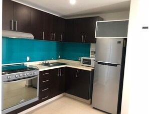 Functional kitchen with gas stove, oven, and modern appliances.