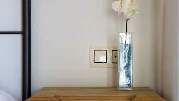A wooden nightstand with a vase of white flowers.