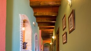 A hallway with green walls, wooden beams, and tiled flooring. - Hostal Valle del Sol Confort Rooms (Álora)