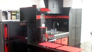 A compact kitchen with a black countertop, red accents, and a microwave. - Universidad Javeriana Cll 41 (Bogotá)