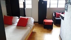 A room with a bed, a small table, and a sofa. - Universidad Javeriana Cll 41 (Bogotá)