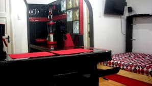 A bedroom with a bed, a mirror, a dresser, and a television on the wall. - Universidad Javeriana Cll 41 (Bogotá)