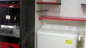 A compact kitchen with a built-in stove, a washing machine, and a small countertop. - Universidad Javeriana Cll 41 (Bogotá)